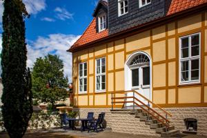 żółty budynek ze stołem i krzesłami przed nim w obiekcie Harzträume No2 Französische Kommandantur w mieście Wernigerode