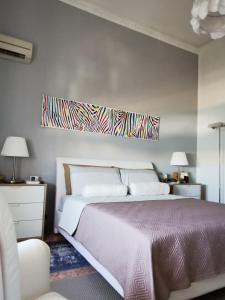 a bedroom with a bed and a painting on the wall at DelleArtiGuesthouse Trapani Porto in Trapani