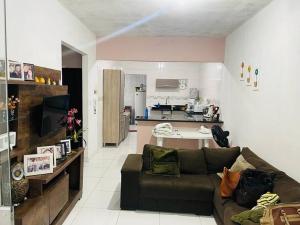 a living room with a couch and a kitchen at Casa p/ temporada, praia guaibim in Guaibim