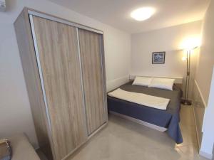 a small bedroom with a bed and a sliding glass door at Studio in Siofok - Balaton 45328 in Siófok
