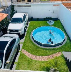 un coche aparcado junto a una piscina en un patio en Casa p/ temporada, praia guaibim en Guaibim
