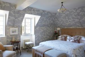 1 dormitorio con 1 cama con papel pintado de flores azul en Hotel Endsleigh, en Milton Abbot