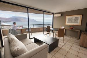 a man sitting at a table in a living room at Terrado Club Iquique in Iquique