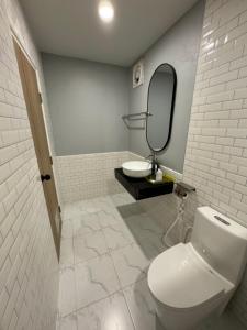 a bathroom with a toilet and a sink and a mirror at S1 City Hotel Buriram in Buriram