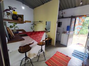 a kitchen with a counter and stools in a room at Chalé dos Lírios in Alto Paraíso de Goiás