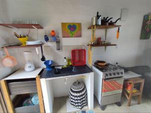 a kitchen with a sink and a stove in it at Chalé dos Lírios in Alto Paraíso de Goiás