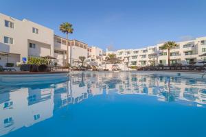 ein Pool in einem Resort mit Gebäuden im Hintergrund in der Unterkunft Apartamentos Galeon Playa in Costa Teguise
