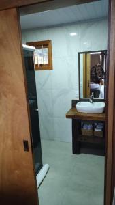 uma casa de banho com um lavatório e um espelho em Pousada Emerich em Cambará