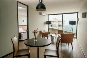1 dormitorio y sala de estar con mesa y sillas. en Terrado Club Iquique en Iquique