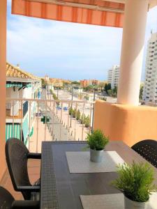 d'un balcon avec une table et des chaises offrant une vue sur la rue. dans l'établissement Stylish Apartment With Terrace Arroyo De La Miel, à Benalmádena