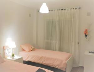- une petite chambre avec deux lits et une lampe dans l'établissement Stylish Apartment With Terrace Arroyo De La Miel, à Benalmádena