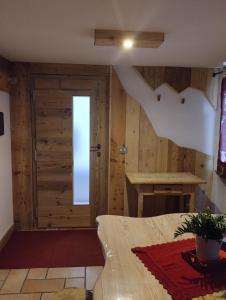 1 dormitorio con paredes de madera y puerta en Botton d'oro en Campitello di Fassa
