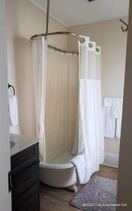a bathroom with a bath tub with a shower curtain at The Charleston Inn Hendersonville NC in Hendersonville