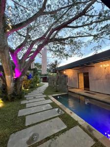 a backyard with a swimming pool and a tree at Hotel Suites Lounge Cañasgordas in Cali