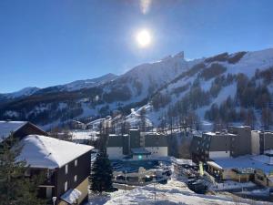 eine Stadt im Schnee mit einem Berg im Hintergrund in der Unterkunft Studio 28 m2 aux étoiles à La Foux Allos in Allos