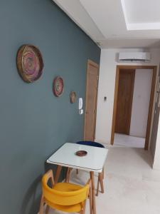 une table blanche et deux chaises dans une pièce dans l'établissement appartement florence, à Tunis
