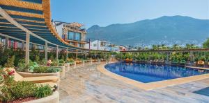 un complejo con piscina y montañas de fondo en Asfiya Loft Apartments, en Kas