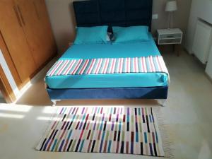 a bedroom with a bed with a colorful rug at appartement florence in Tunis