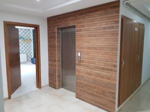 Cette chambre est dotée d'un mur en bois et d'une porte. dans l'établissement appartement florence, à Tunis