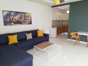 - un salon avec un canapé bleu et une table dans l'établissement appartement florence, à Tunis
