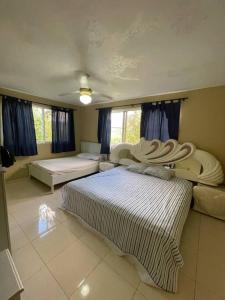 ein großes Schlafzimmer mit 2 Betten und einem Sofa in der Unterkunft Villa Don Manuel in Villa Altagracia