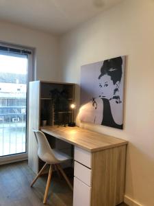 a desk with a chair and a painting on the wall at Berg-Hof in Pfaffenhofen an der Ilm