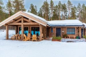 a log cabin with a table and chairs in the snow at ElveRo Lodge in Trysil