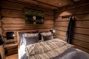 1 dormitorio con 1 cama en una cabaña de madera en ElveRo Lodge, en Trysil