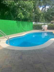 a swimming pool with a green fence around it at Residencial Joyas D’ Luxe III A3 in Santiago de los Caballeros