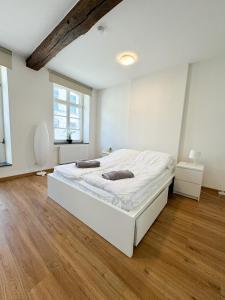 a white bedroom with a large white bed in it at Praktisch & modern - voll ausgestattetes Apartment in Stolberg