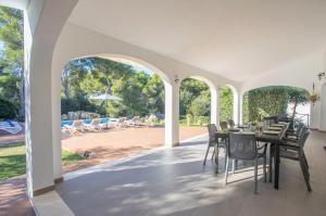 an outdoor dining room with a table and chairs and a patio at Villa Macarella by Sonne Villas in Cala Galdana