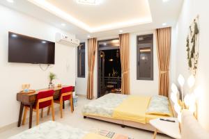 a bedroom with a bed and a table and a desk at The Sophia Apartment - Thao Dien Central in Ho Chi Minh City