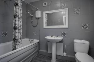 a bathroom with a sink and a toilet and a bath tub at Beautiful Family Home in Blackpool for you in Blackpool