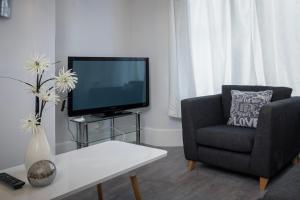 a living room with a tv and a chair at Beautiful Family Home in Blackpool for you in Blackpool
