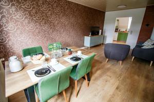 Un comedor con una mesa y sillas verdes. en Harzträume No1 & No2 # Parkplatz # Altstadt # Brockenbahn, en Wernigerode 17 fotos más
