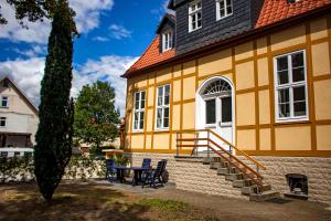 een geel gebouw met een tafel en stoelen ervoor bij Harzträume No1 & 2 Doppelwohnung in Wernigerode