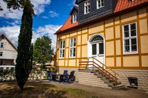 un edificio amarillo con una mesa y sillas delante de él en Harzträume No1 & No2 # Parkplatz # Altstadt # Brockenbahn, en Wernigerode