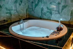 a bath tub filled with water in a bathroom at Smaragdi Luxury Jacuzzi Apartment Noho Premium Living in Athens