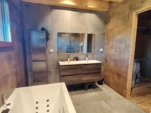 baño grande con bañera y lavamanos en Svea Lodge, en Thollon-les-Mémises