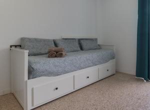 una cama blanca con un osito de peluche sentado en ella en Apartamentos Bello Lanzarote en Arrecife