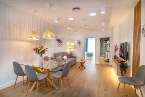 a dining room and living room with a table and chairs at MQ Suites Veronica in Valdepeñas