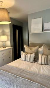 a bedroom with a bed with pillows on it at Guest Homes - Rice Lane Retreat in Walton on the Hill
