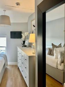 a bedroom with a bed and a dresser with a mirror at Guest Homes - Rice Lane Retreat in Walton on the Hill