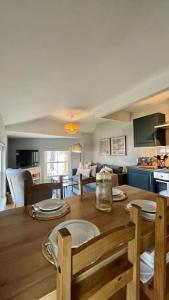 eine Küche und ein Wohnzimmer mit einem Holztisch und Stühlen in der Unterkunft Guest Homes - Rice Lane Retreat in Walton on the Hill