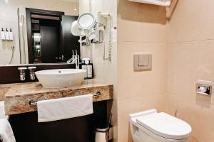 a bathroom with a white sink and a toilet at Crowne Plaza Bratislava, an IHG Hotel in Bratislava