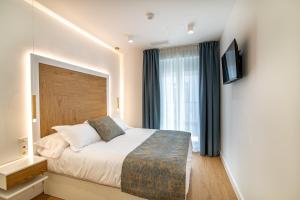 a hotel room with a bed and a window at MQ Suites Veronica in Valdepeñas