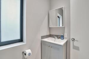 a white bathroom with a sink and a mirror at Condo Right off Las Olas Steps to FTL Beach 1A in Fort Lauderdale +64 photos