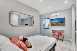 a bedroom with a bed and a mirror and a table at Condo Right off Las Olas Steps to FTL Beach 1A in Fort Lauderdale