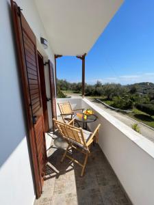 a balcony with two chairs and a table on it at Jimmy's Guest House Skiathos in Skiathos