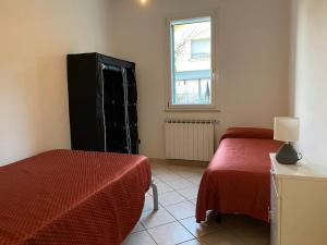 a bedroom with a bed and a black refrigerator at SistersHome in Cervia